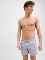 Short de baño de tiro medio en color lila, con cintura elástica y cordón ajustable. Presenta un diseño minimalista con el logo de la marca estampado en la parte inferior derecha.