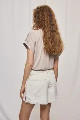 Short de jean blanco de tiro medio con silueta relajada y detalle de ruedo desflecado con flecos.
