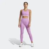 Top deportivo Adidas de soporte medio, color lila, con cuello redondo, espalda cruzada y múltiples bolsillos ocultos. Presenta el logo de Adidas en blanco en el pecho.