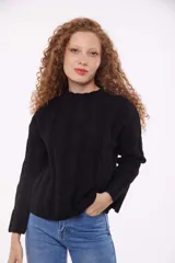 Sweater negro de punto con cuello redondo y mangas largas.