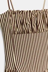 Vestido midi de popelín con estampado de rayas verticales. Presenta escote recto con detalle de pliegues, tirantes finos y falda con corte evasé. Incluye cierre lateral con cremallera oculta.