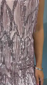 Vestido corto de fiesta color rosa pálido con breteles finos y escote en V. Presenta múltiples flecos con lentejuelas plateadas.