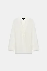 Camisa blanca ZARA Woman Collection de 100% seda, con escote en V ajustable con cordones entrelazados y manga larga con puños rectos.