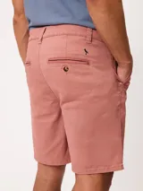 Bermuda Ursus modelo Polanco, confeccionada en tejido de gabardina color coral. Cuenta con presillas para cinto, cierre frontal con botón y bolsillos laterales y traseros.