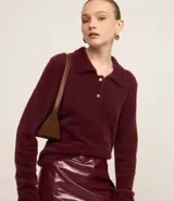 Saco de punto afelpado color bordó, de manga larga, con cuello polo y cierre frontal de dos botones.