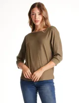 Blusa de tejido acanalado con cuello redondo y mangas tres cuartos. Presenta detalle de tachas metálicas a lo largo de los hombros y mangas, con puños elastizados.