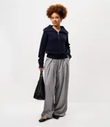 Pantalón de sastrería modelo pantalona, de corte amplio y tiro alto. Presenta pinzas frontales, cierre con cremallera y botón, y presillas en la cintura. Incluye un cinturón ajustable del mismo tejido.