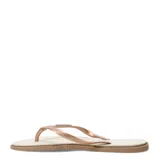 Sandalias tipo ojota Havaianas con base texturizada en color crema y suela marrón. Presenta tiras finas en color oro rosa con detalle de apliques brillantes.