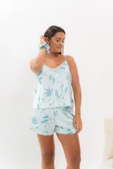 Pijama de seda estampada con diseño floral en tonos celestes y blancos. Incluye una musculosa con escote en V y espalda recta, y un short con elástico en la cintura.