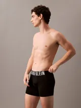 Pack de tres boxers largos de microfibra con cintura elástica distintiva de Calvin Klein. Incluye un modelo negro, uno beige y uno bordó.