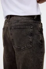 Jean de corte recto y calce regular, confeccionado en denim de algodón con efecto lavado desgastado en tono gris oscuro. Presenta diseño clásico de cinco bolsillos, cierre frontal con botón y costuras reforzadas.