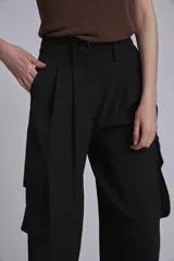 Pantalón cargo negro de corte ancho, con bolsillos laterales con fuelle y trabillas en la cintura.