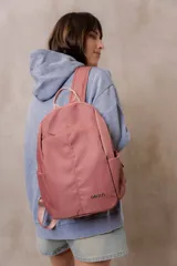 Mochila compacta de color beige, con compartimento principal con cierre, bolsillos laterales y bolsillo frontal con cierre oculto. Cuenta con correas regulables y acolchonadas y asa superior.