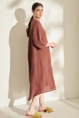 Túnica midi marrón de lino, con cuello mao, cierre frontal con botones y bolsillos laterales.