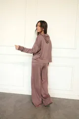 Canguro con capucha de manga larga, color marrón topo, de calce amplio y tejido suave. Presenta bolsillo canguro frontal y puños y ruedo ajustados.