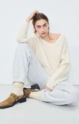 Sweater de punto fino con cuello a la base y mangas largas, confeccionado en hilo italiano con textura mullida y corte holgado.