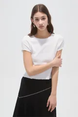 Remera de manga corta blanca de punto canalé, con corte entallado y cuello redondo a la base.