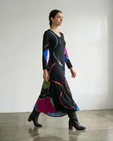 Vestido largo de corte fluido con escote en V y mangas largas. Presenta una estampa exclusiva con diseño orgánico de líneas abstractas en colores vibrantes sobre base negra.