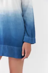 Vestido corto con diseño degradado en tonos blanco y azul, de corte recto, manga larga y cuello redondo.