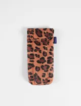 Estuche para lentes de la marca Baggu, confeccionado en tela acolchada con estampado animal print en tonos naranja, marrón y negro. Posee un diseño alargado con solapa de cierre superior y una etiqueta lateral con el logo de la marca.