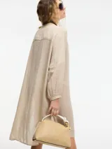 Vestido túnica camisera color negro con botones en la parte delantera, cuello mao y detalle de bordado en el pecho y mangas. Presenta tajos verticales laterales.