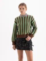 Sweater de cuello redondo confeccionado en lana merino, con diseño de rayas verticales en tonos marrón y verde que integran una trama de ochos. Presenta cuello, puños y cintura en color marrón sólido.