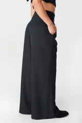 Pantalón de tiro alto con corte holgado y pierna ancha. Presenta bolsillos laterales ocultos en la costura y una faja desmontable ajustable en la cintura.