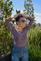 Body de jersey de lana merino color lila con estampado botánico en tonos dorados.