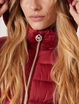 Campera puffer Michael Kors de color blanco, con diseño acolchado, cierre frontal metálico, bolsillos laterales con cierre y capucha desmontable. Incluye bolsa autoportante para guardado.