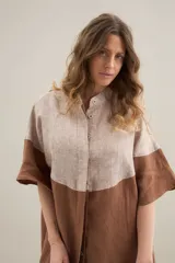 Camisa larga de lino con diseño bicolor en tonos beige y marrón, cuello mao y mangas cortas.