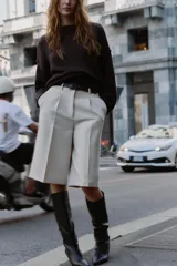 Bermuda larga color marrón oscuro, tiro medio, con pinzas frontales y cinturón de textura animal print plateado.