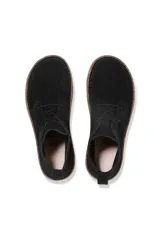 Bota de gamuza negra con cordones, suela de goma y detalle de costura en la base.