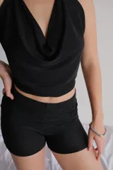 Mini short de tiro alto confeccionado en tela con acabado brillante y destellos, de corte ajustado.