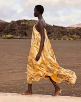 Vestido largo y fluido de seda lúrex en color amarillo, con estampado inspirado en pañuelo, escote en V, tirantes ajustables y bajo con volante.