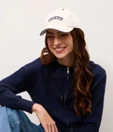 Gorra de sarga color blanco crudo, con visera curva, costuras contrastantes y bordado frontal con el texto "Tokyo" en color azul marino.