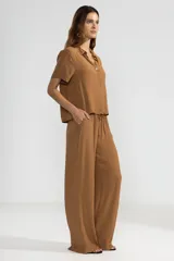 Pantalón de crepe color marrón, de corte recto con cintura elastizada y bolsillos laterales.