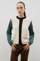 Saco de punto con diseño color block, presenta cuerpo en color bordó, mangas en color rojo y tapeta frontal con cuello redondo en color rosado. Posee cierre frontal con botones y puños acanalados.