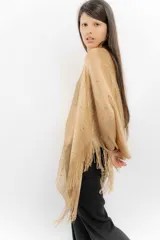 Poncho de tejido de punto metalizado en color dorado, con diseño amplio y flecos en el borde inferior. Presenta apliques sutiles de piedras y un estilo holgado.