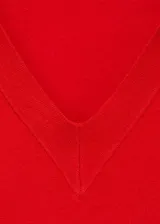 Jersey de punto fino color rojo, con cuello en V y solapas tipo polo, de manga larga y diseño recto.