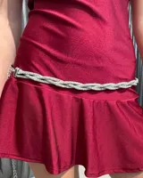Cinturón tipo caderín de diseño trenzado, elaborado con múltiples hileras de strass plateado. Cuenta con cierre de gancho y cadena de ajuste metálica.