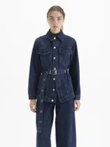 Parka larga de denim azul oscuro, con cuello camisero, bolsillos delanteros con tapa y cinturón ajustable con arandelas metálicas.