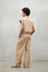 Camisa azul marino con cierre frontal de botones y dobladillo ajustable con cordones de tela.