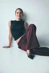 Pantalón de vestir de pierna ancha, color bordó oscuro, con finas rayas verticales en tono similar. Presenta cintura clásica con cierre de botón y bolsillos al bies.