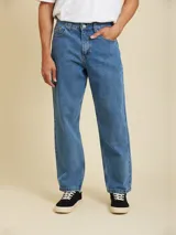 Jean de corte loose fit, color azul medio, con diseño clásico de cinco bolsillos y cierre frontal con botón metálico.