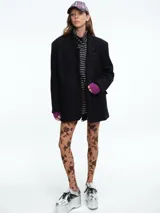 Chaqueta de silueta estructurada con hombreras, solapas clásicas y cierre frontal con botones. Confeccionada en lana con forro de poliéster.