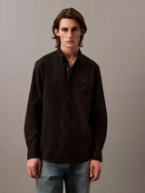 Camisa negra de manga larga con cuello abotonado y logo de Calvin Klein bordado en el pecho.