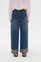 Pantalón jean de corte baggy y tiro medio, con diseño amplio y dobladillo vuelto que deja ver un detalle estampado en el interior.