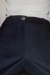 Pantalón de tiro alto con pernera recta, confeccionado en denim oscuro. Presenta nervios marcados en el delantero, bolsillos frontales tipo parche y cierre frontal con cremallera y botón.