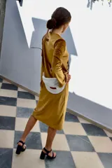 Vestido midi de terciopelo mostaza, de manga larga con detalles en los puños, cuello redondo y corte recto.