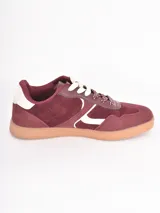 Championes de estilo urbano en color bordó, confeccionados en gamuza con detalles en cuero blanco. Presentan cordones gruesos con estampado de lunares y suela de goma color caramelo.